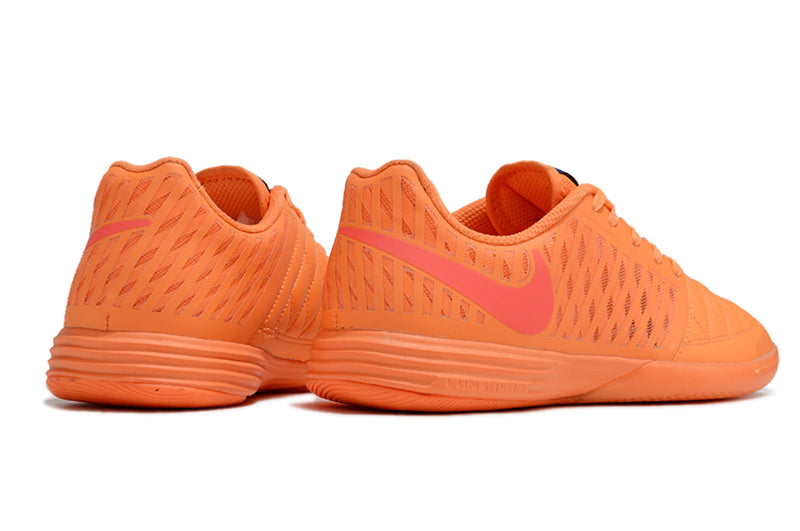 Chuteira futsal Nike Lunar Gato II na cor laranja, com detalhes em rosa e design leve.