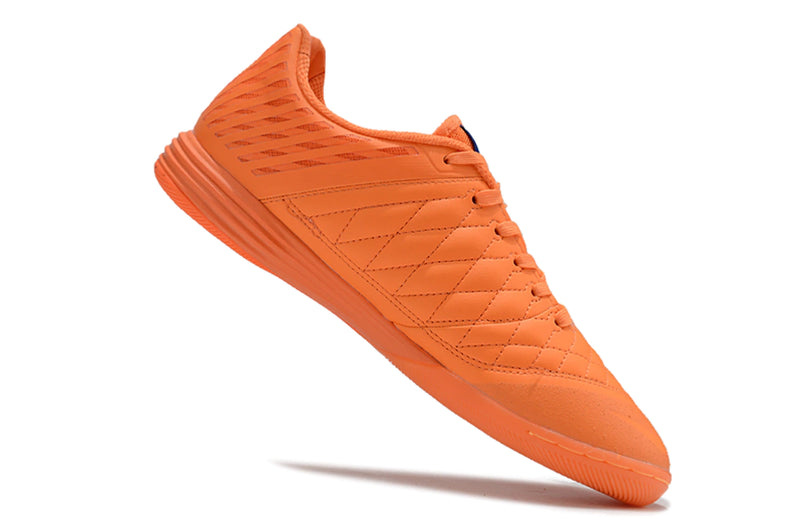 Chuteira futsal Nike Lunar Gato II na cor laranja, com detalhes em rosa e design leve.
