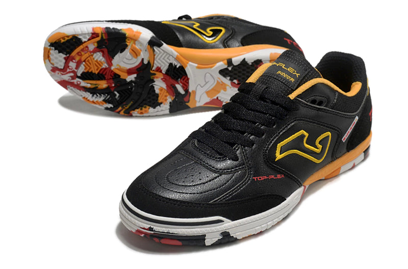 Chuteira de futsal Joma Top Flex Rebound na cor preta com detalhes em amarelo e vermelho.
