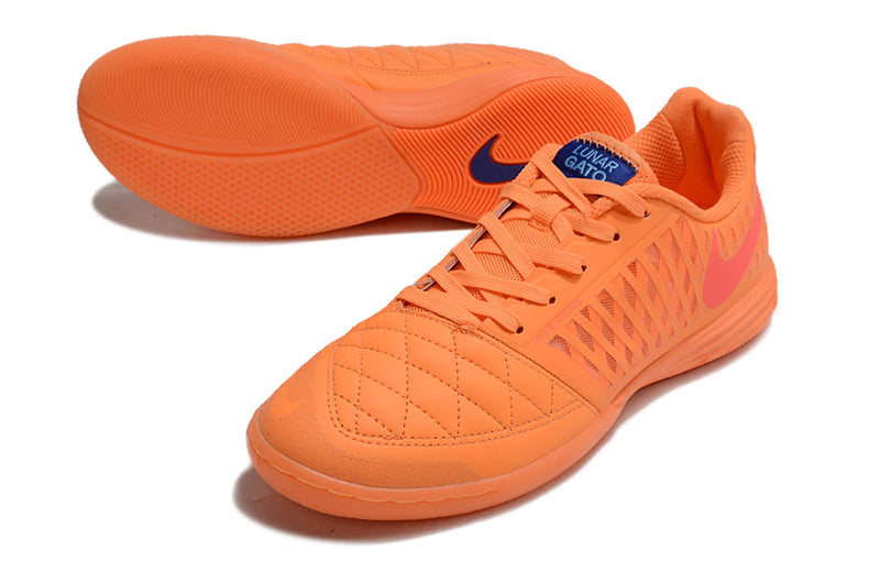 Chuteira futsal Nike Lunar Gato II na cor laranja, com detalhes em rosa e design leve.
